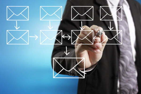 man drawing envelope icons with a marker on glass