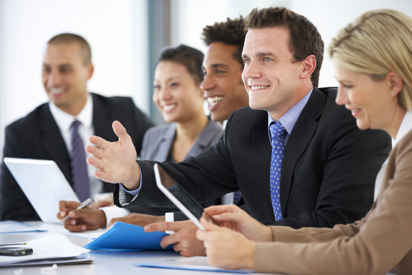 5 people in suits smiling at a meeting