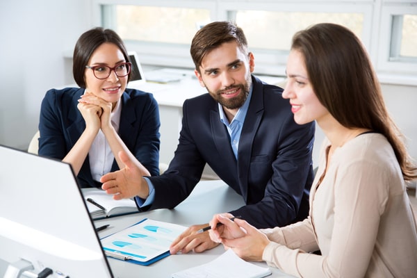 2 people showing woman something on computer