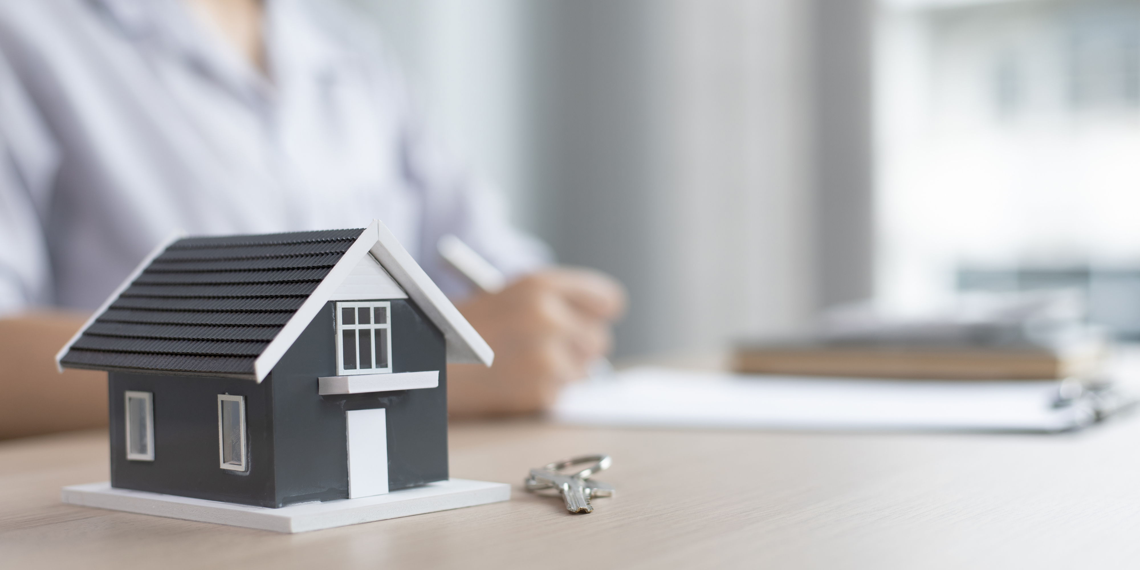 house and keys next to paperwork